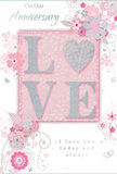 This anniversary card offers a tender tribute to enduring romance, much like a carefully chosen bouquet arriving at a doorstep in Belsize Park. The design centres on the word LOVE, each capital letter raised slightly from the card and dusted with a fine, soft glitter that shimmers in blush pink and silvery white. The letter O is subtly transformed into a shimmering heart shape, textured in silver so it glows with a quiet intensity, recalling the metallic highlights sometimes used in luxury wrapping by local florists. Around this focal word, a soft garden of illustrated flowers unfolds across a pastel pink background. The blooms appear in gentle shades of blush, mauve, and ivory, painted with an almost watercolour softness so their edges fade delicately into the surrounding colour, like petals resting on a café table near England's Lane. Fine lines trace stems and leaves in silvery grey, forming graceful curves and loops that suggest both care and spontaneity. Tiny details-fluttering petal shapes, swirling flourishes, and subtle butterfly silhouettes-add a sense of light movement, as if a spring breeze from nearby Primrose Hill has touched the page. Above and below, the phrases On Our Anniversary and I love you today and always are written in a refined, flowing script that feels personal and heartfelt rather than formal. The entire composition creates a soft, intimate atmosphere, ideal for celebrating a shared journey of love in North West London with all the tenderness of a hand-delivered anniversary bouquet.
